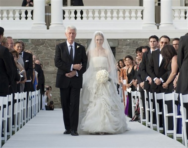 FILE - This July 31, 2010 file photo released by Genevieve de Manio Photography shows former President Bill Clinton walking his daughter Chelsea down the isle for her wedding in Rhinebeck,N.Y. No one, including Clinton and designer Wang, expected the media circus that accompanied last year's wedding, says Darcy Miller, editor in chief of Martha Stewart Weddings, but all those photos and attention meant that a lot of gowns are coming out now that were inspired by the delicate strapless with a jeweled waistband. \"It was copied in the industry immediately. It's the classic, romantic, fairy-tale dress on a modern woman.\"     (AP Photo/Genevieve de Manio Photography,Genevieve de Manio, File) NO SALES; EDITORIAL USE ONLY